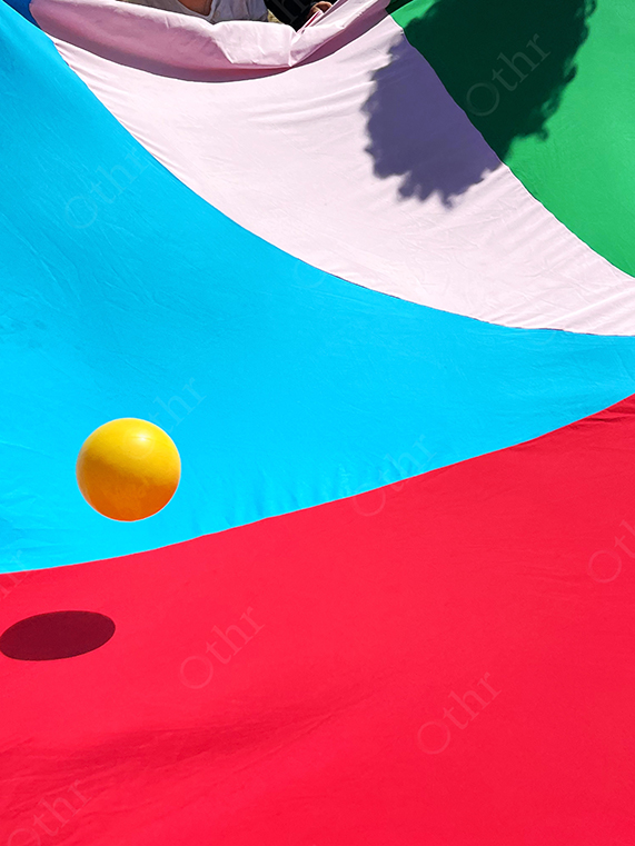Yellow Ball Bouncing on Colourful Fabric Surface
