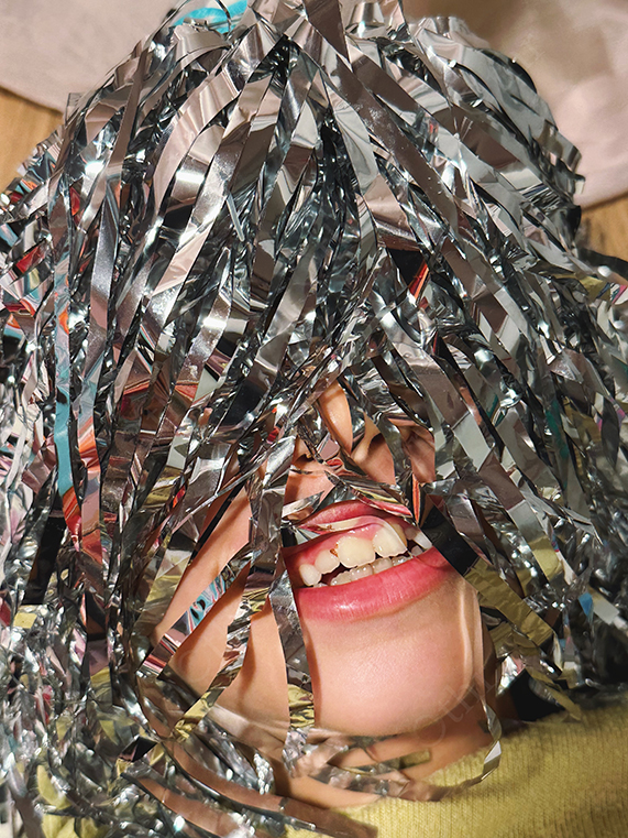 Child's Face Covered With Silver Foil Strips in Close-Up