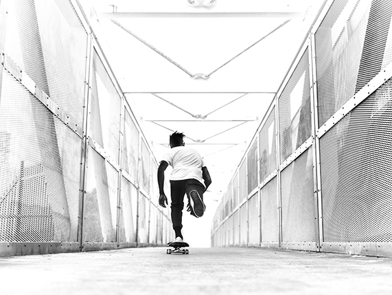 Skateboarder Riding Through a Bright Overexposed Metal Walkway