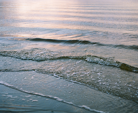Gentle Waves Rolling Onto a Shoreline at Sunset