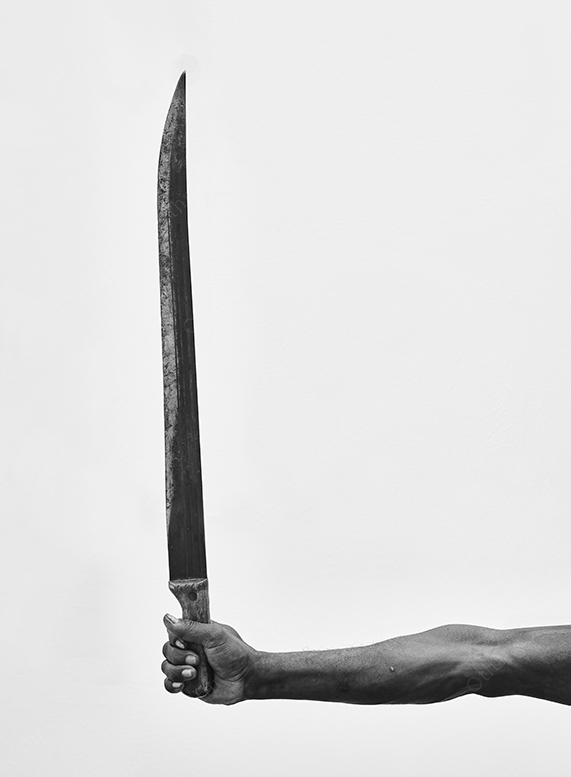 Arm Holding a Long Blade Against a High-Key Background