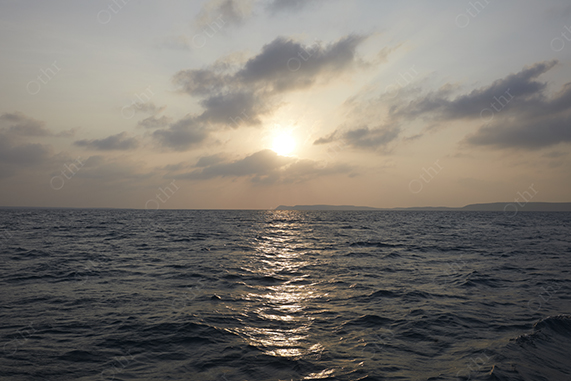 Sunset Over a Calm Ocean With Soft Clouds and Reflected Light