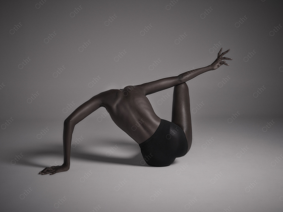 Contemporary Nude Pose With Outstretched Arm in Soft Studio Lighting