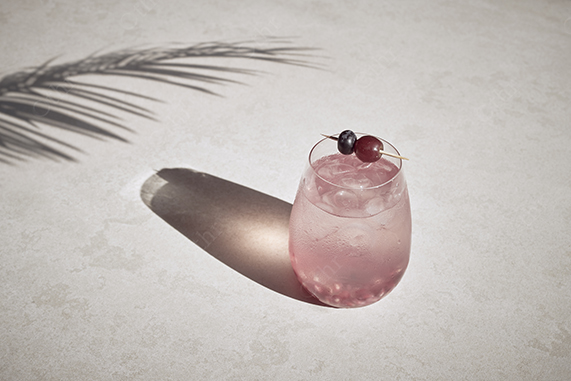 Pink Iced Drink With Fruit Garnish Casting a Long Shadow in Sunlight