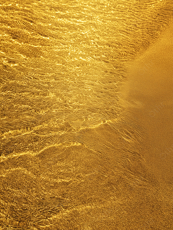 Golden Shoreline With Gentle Waves Washing Over Sand