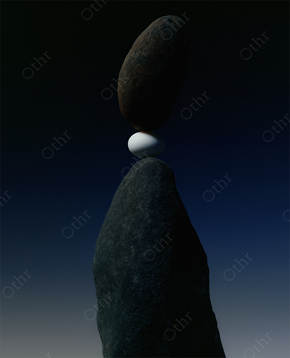 Still life of an egg held between rocks at dusk.