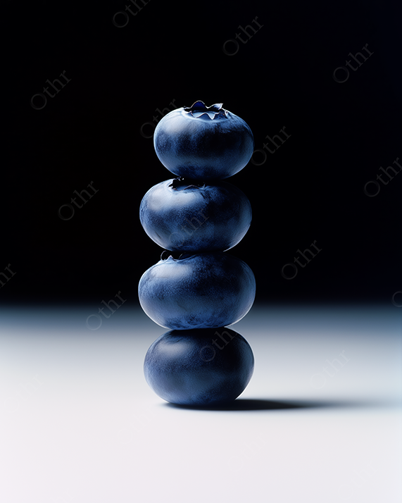 Blueberries stacked on top of each other with dramatic studio lighting.