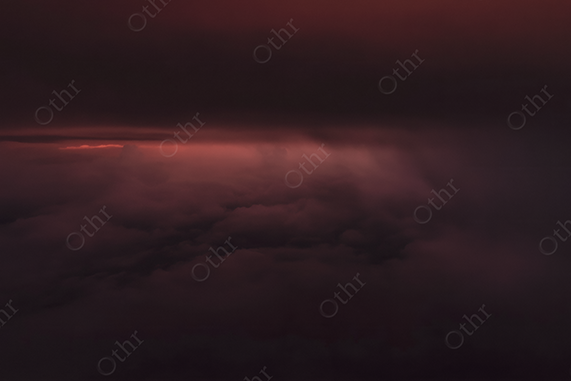 Red Light Breaking Through Dense Storm Clouds at Dusk