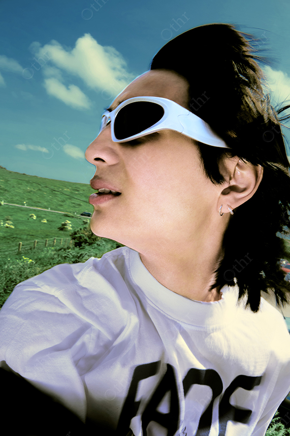 Close-Up Side Profile of Person Wearing White Sunglasses Outdoors Against Green Hills and Blue Sky