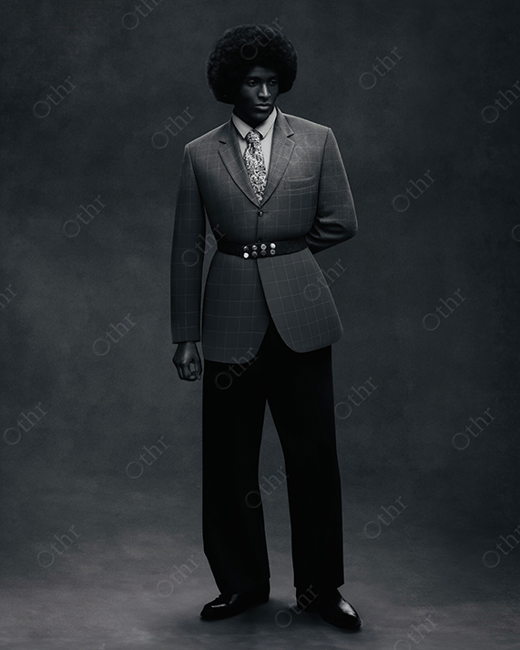 Studio Portrait of Person in Tailored Suit Standing Against Dark Textured Background in Low-Key Lighting