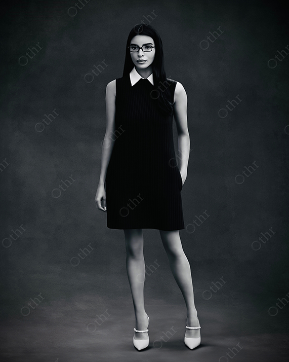Studio Portrait of Woman Wearing Black Sleeveless Dress and Glasses Standing Against Dark Background