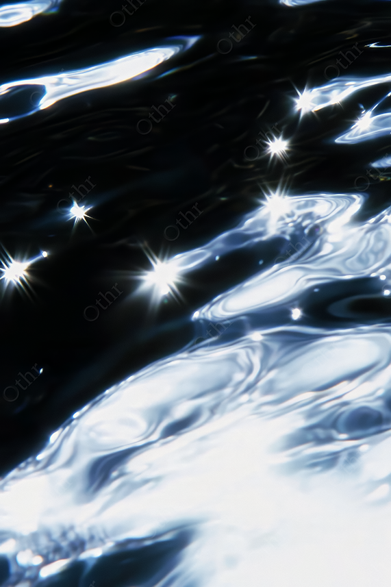 Abstract Highlights and Ripples on Dark Water Surface With Starburst Light Reflections