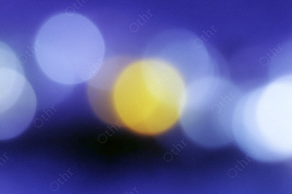 Defocused Bokeh Light Orbs With Yellow Highlight on Deep Blue Background