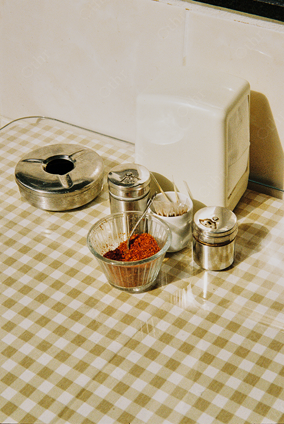 Tabletop Still Life of Metal Condiments and Spice Bowl on Checkered Surface