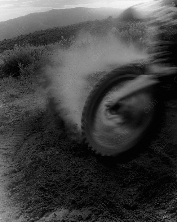 Motocross bike tire skidding in dirt.