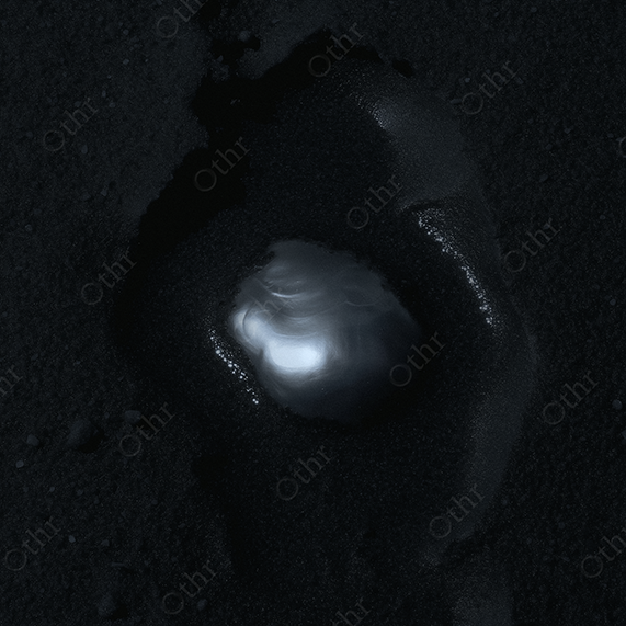 Baroque pearl set in black sand.
