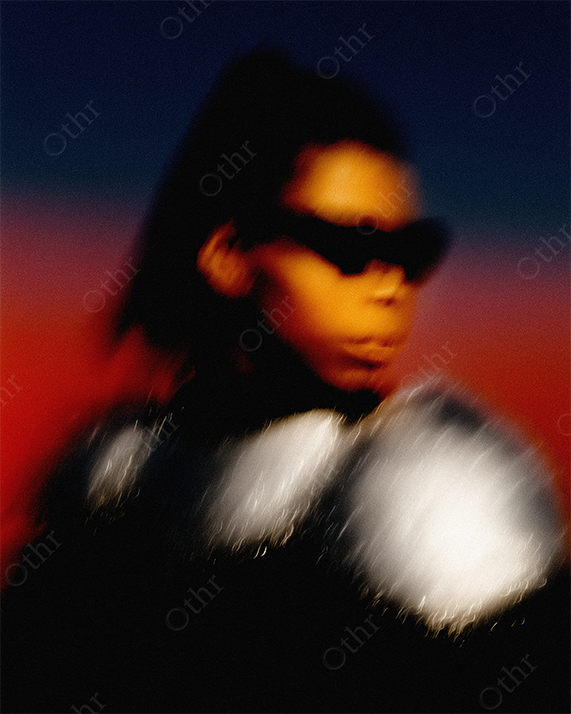 Blurred fashion portrait of woman wearing sunglasses and chainmail with a blue-red gradient background.