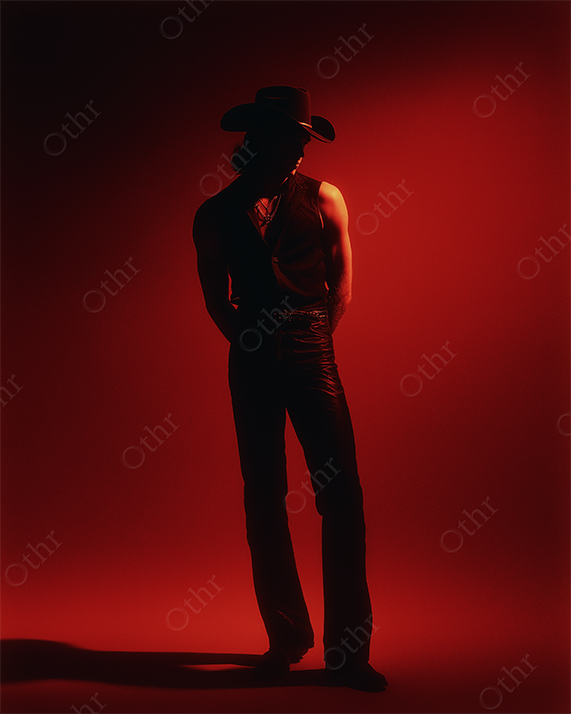 A cowboy figure silhouette with a red background.