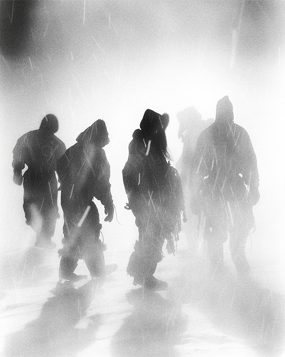 Group of travelers walking into snowy mist