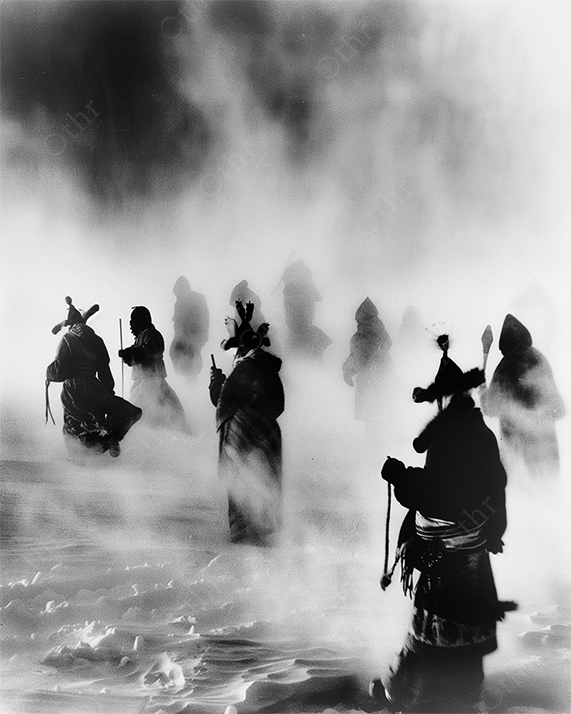 Hooded explorers in monochrome snowstorm
