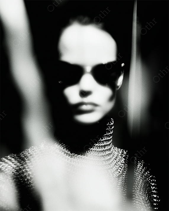 Woman with sunglasses and sword in shadow