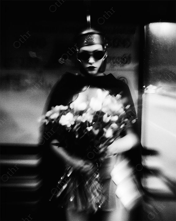 Woman in black cloak holding flowers