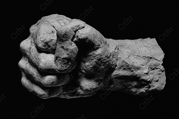 A white stone fist on black background.