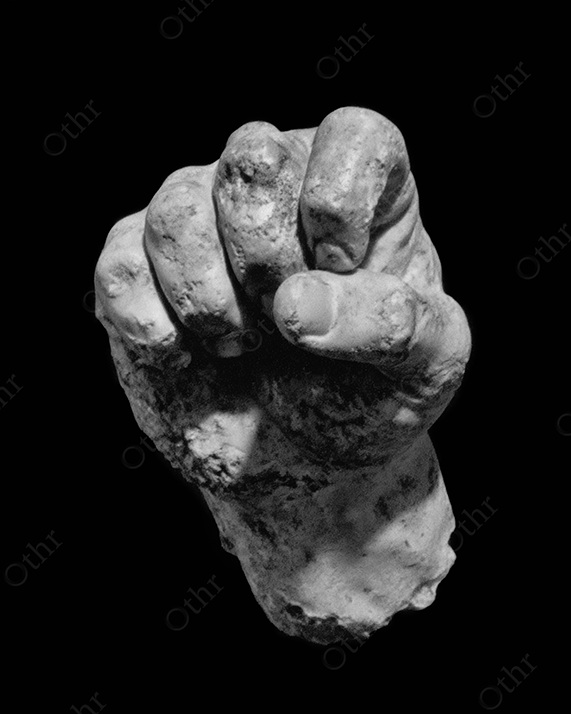 A white stone hand on black background.
