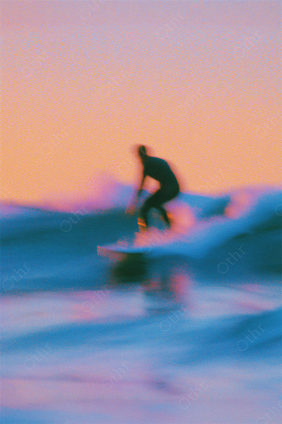 Surfer riding wave in dreamy pink-blue twilight