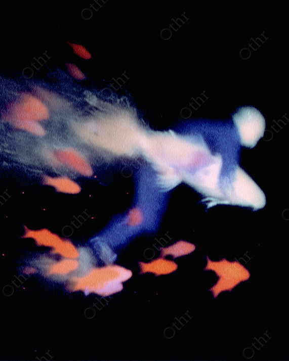 High-speed swimmer with fish streaking past in dark void