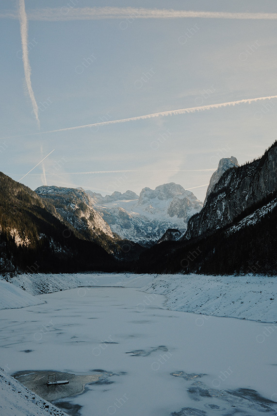 Frozen Alpine River Winding Through Mountain Valley at Dusk