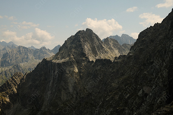 Wide View of Rocky Mountain Range Beneath Scattered Clouds
