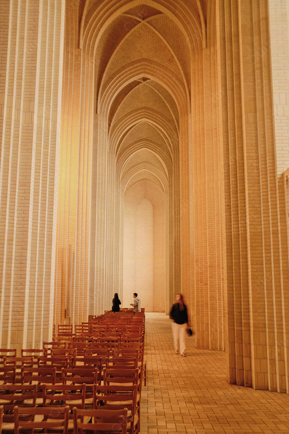 People Walking Through Long Arched Cathedral Aisle with Repeating Columns