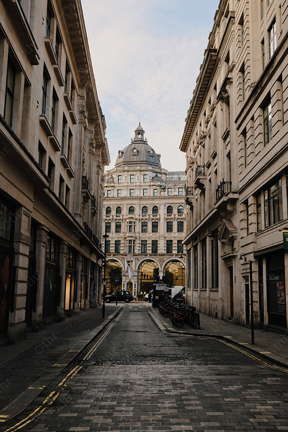 Narrow City Street Leading to Domed Historic Building in Soft Daylight