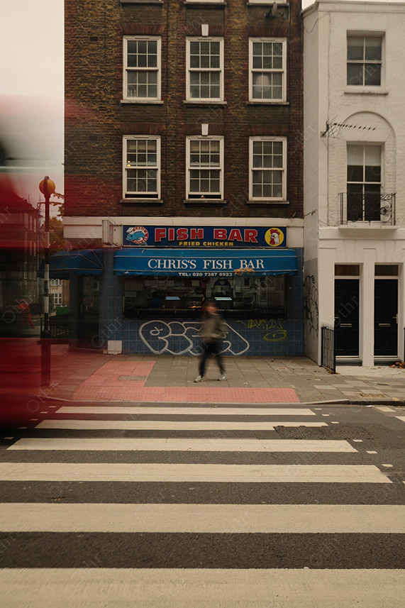 Fish Bar Shopfront With Signage and Pedestrian Motion Blur at Zebra Crossing