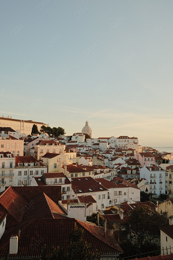 Hillside City Rooftops and Domed Building in Golden Hour Light Under Clear Sky