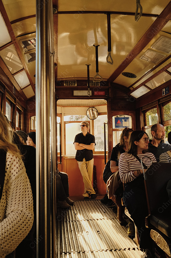 Passengers Sitting Inside Vintage Tram Car With Sunlight Streaming Through Windows