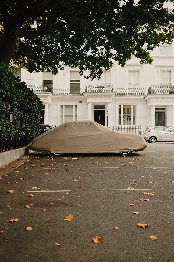 Covered Car Parked on Residential Street With Fallen Leaves and White Terrace Houses