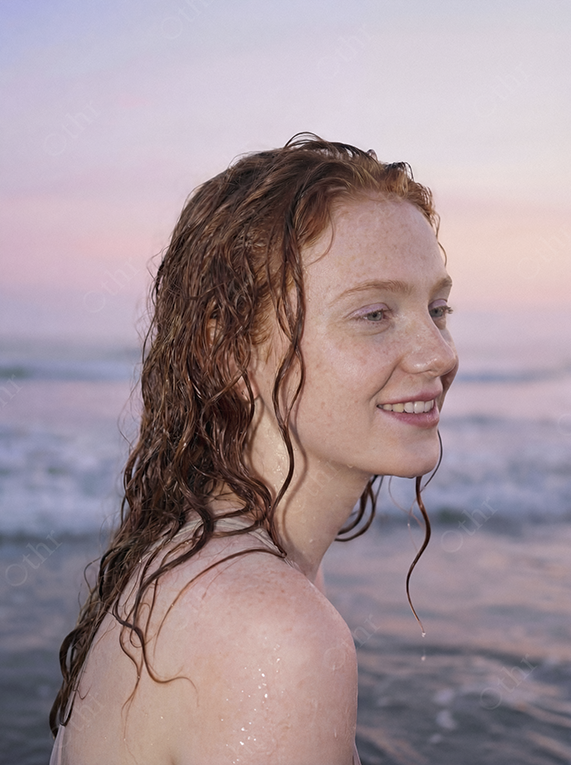 Close-Up Portrait of Red-Haired Woman With Wet Hair at Beach Sunset