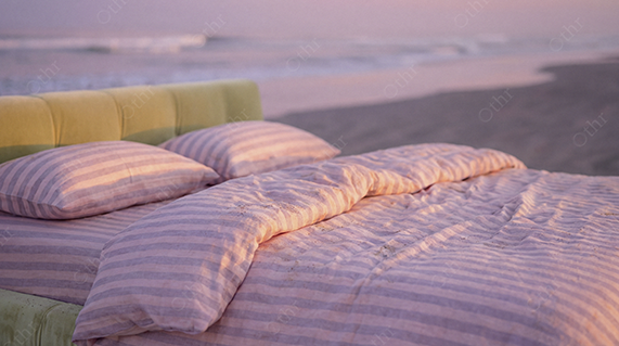Close-Up of Striped Pink Duvet and Pillows on Bed at Beach