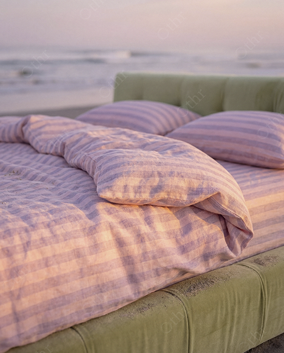 Close-Up of Pink Striped Duvet on Green Bed Frame at Beach
