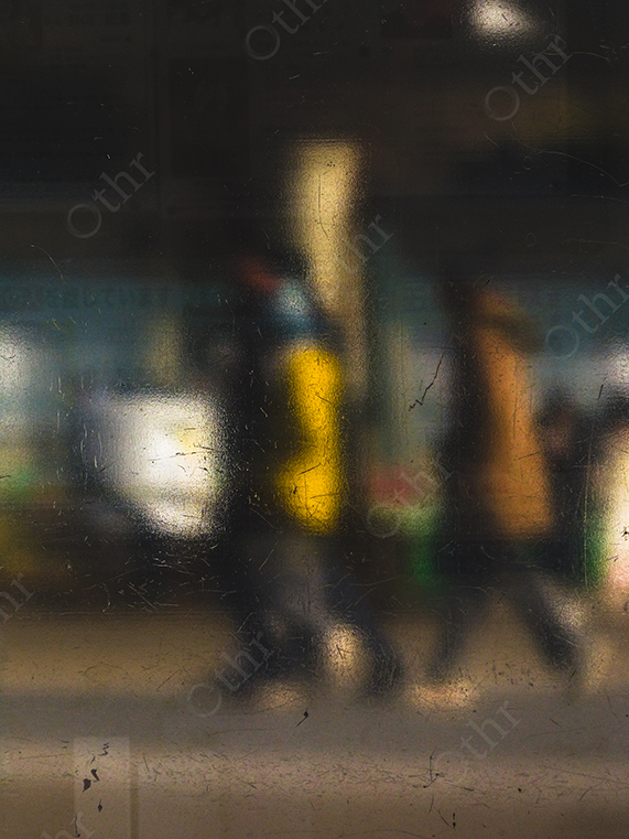 Blurred Pedestrians Seen Through Dirty Glass Window in Urban Night Scene