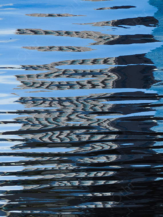 Abstract Distorted Reflection of Building on Rippling Blue Water Surface