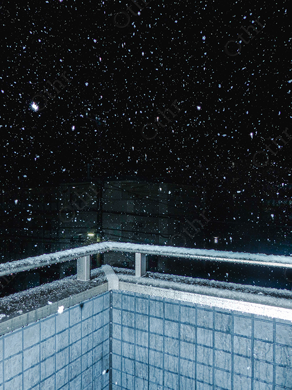 Snowfall Over Tiled Balcony Railing in Night-Time Urban Scene