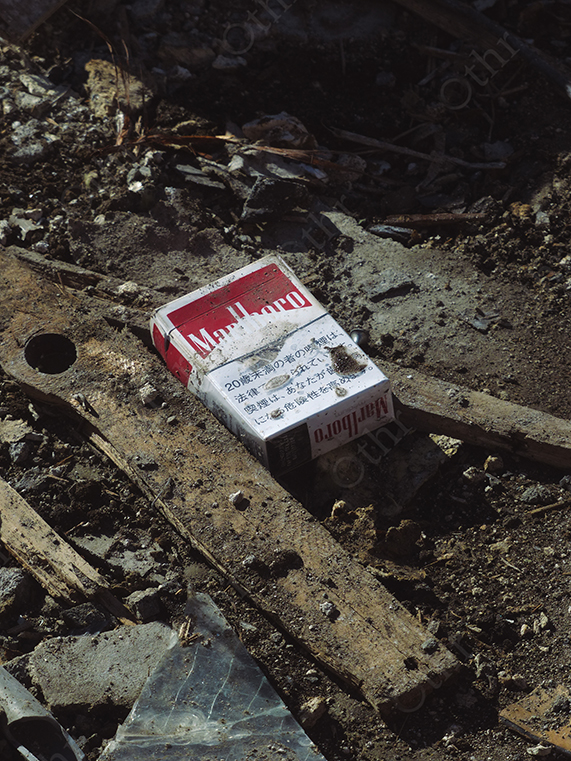Discarded Marlboro Cigarette Pack on Dirt and Debris with Harsh Natural Light