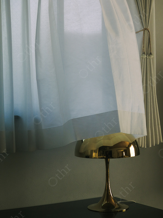 White Curtain Draped Over Metallic Table Lamp with Soft Indoor Light