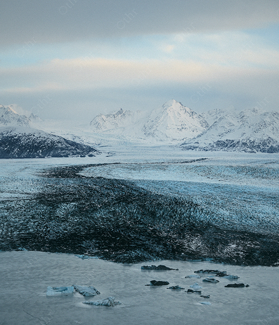 Glacier Field Leading to Snow Covered Mountains Under Soft Overcast Sky
