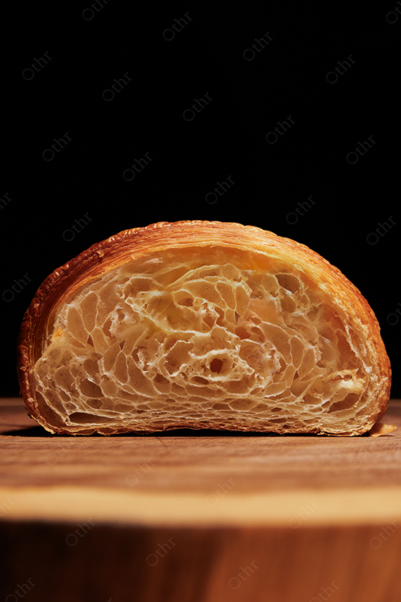 Close-Up Cross Section of Croissant Showing Layered Texture on Wooden Surface