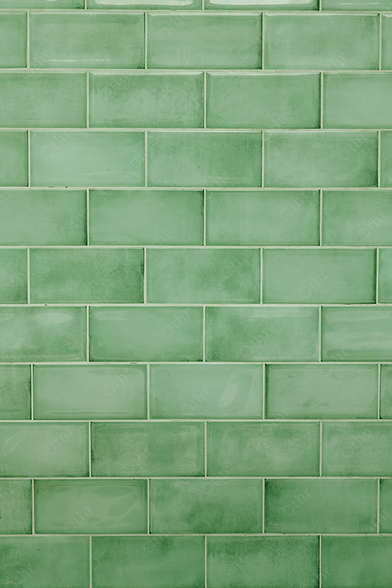 Green Glossy Subway Tiles Forming Repeating Pattern With Soft Texture Variations
