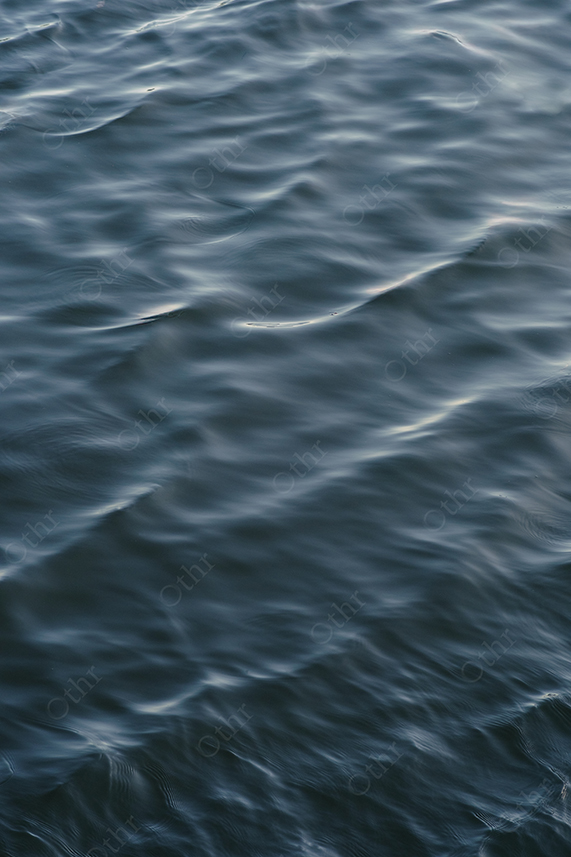 Close-Up of Blue Water Surface With Gentle Waves and Soft Light Reflection